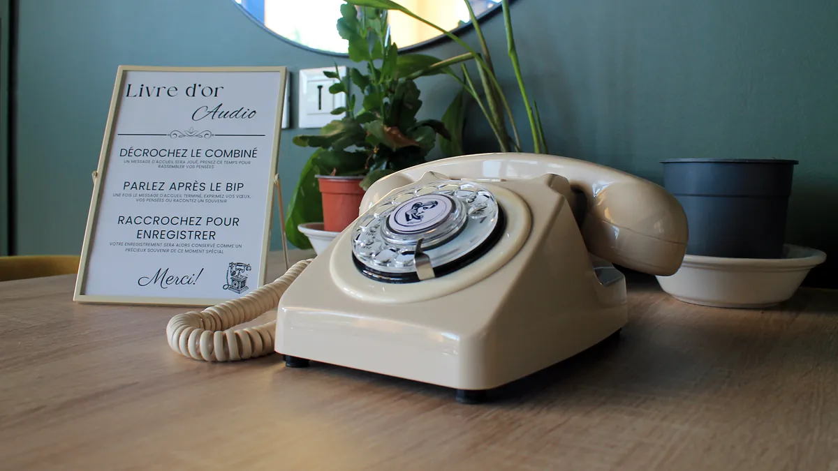Cream vintage phone and its audio guestbook sign on a table