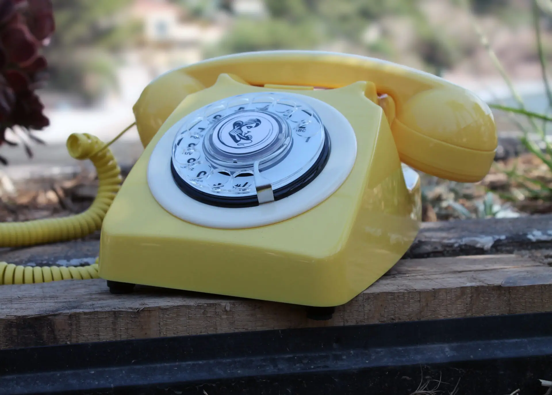 Téléphone vintage jaune avec cadran rotatif utilisé pour le livre d'or audio.